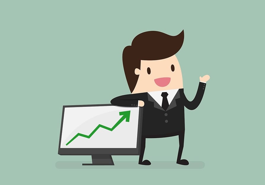Man standing over computer monitor with growth chart going up